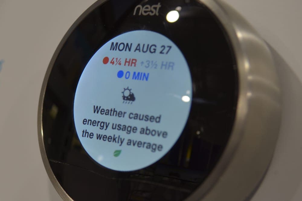 Smart thermostat on a wall showing the day's heating and cooling use